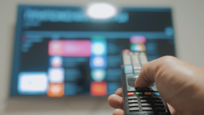 Smart tv with apps and hand. Male hand holding the remote control turn off smart tv . man hand lifestyle controls TV holding remote. TV concept internet online cinema | Shutterstock HD Video #1020911095