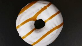 donut with different fillings and icing on black background. Rotation video. Top view