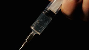 Medical syringe with liquid on black background. Close up. research scientist hand 