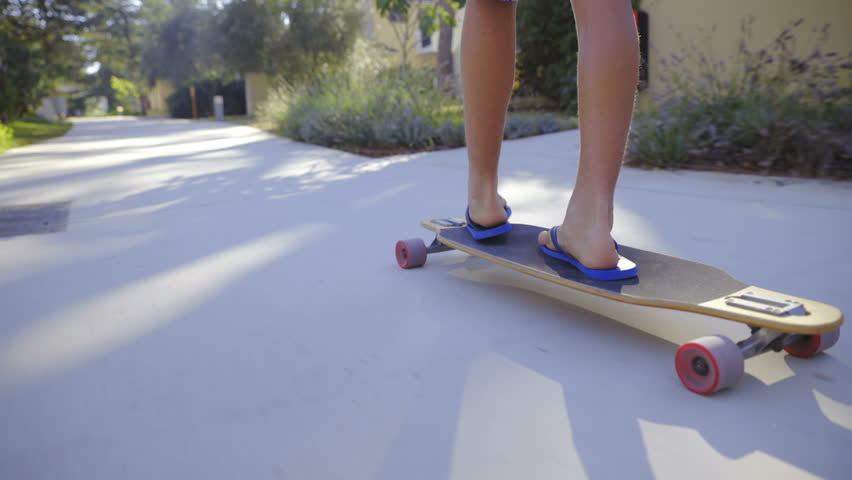 Legs Wearing Flipflops Riding Longboard 
