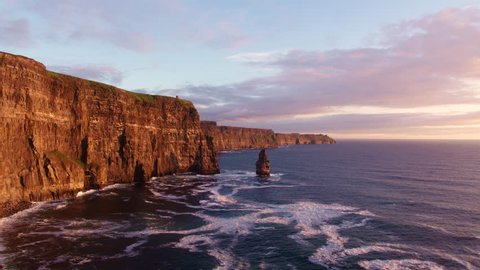 Aerial drone footage of the beautiful Cliffs of Moher off the west coast of Ireland. Waves crashing against the foot of the cliffs located on the Wild Atlantic Way. Scenic view of sea and mountain 