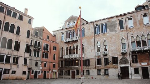Venetian Flag with Winged Lion waving on the Wind in a Square of Venice, Italy. 