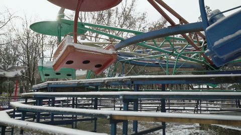 Empty carousel covered with snow in amusement park in winter