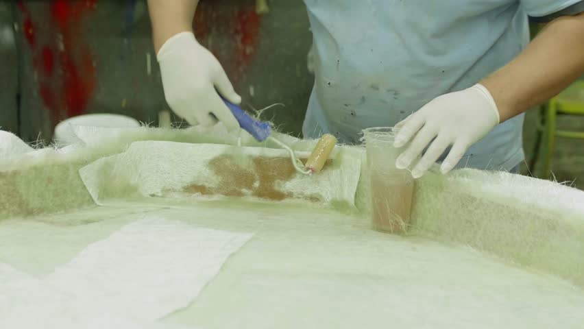 Man enhances wooden construction with gel coat and synthetic fibre