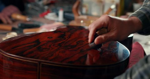Close up of professional lutist's hands make high quality handmade traditional classic wooden guitars for musicians. Concept of arts, music, ancient tradition, woodcraft