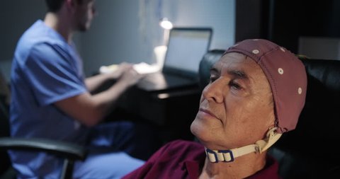 Elderly male patient with Alzheimer's illness, undergoing electroencephalogram examination Senior man with a nurse in clinic for medical evaluation using EEG. Brain illness prevention using technology