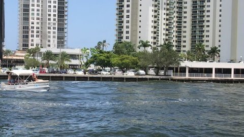 Hallandale, Florida - July 7, 2018: A beautiful small pontoon boat is seen gliding down rough water on the intercoastal waterway on this date 
