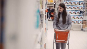 Footage young women selecting napkin for house at supermarket. 4K video