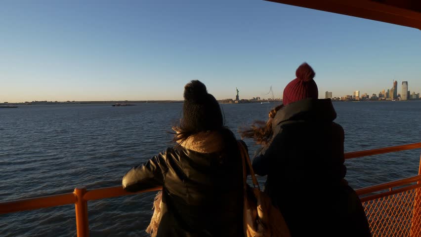 Two girls ride the Staten Island Ferry on a sunny day