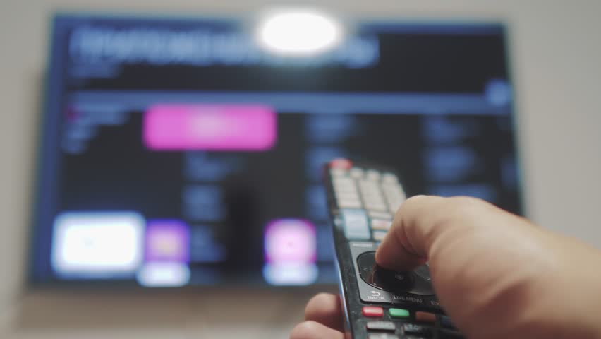 Smart tv with apps and hand. Male hand holding the remote control turn lifestyle off smart tv . man hand controls TV holding remote. TV concept internet online cinema | Shutterstock HD Video #1021006255