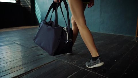 Slow motion fit young woman legs entering gym with sports bag, preparing for boxing training. Female boxer athlete on floor, taking bandage tape. wellness, fighting, motivation, self defense concept