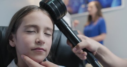 Little Caucasian girl with autism receives Transcranial Magnetic Stimulation in pediatric medical clinic. Young girl with Asperger disorder receives alternative treatment for neurological disorder