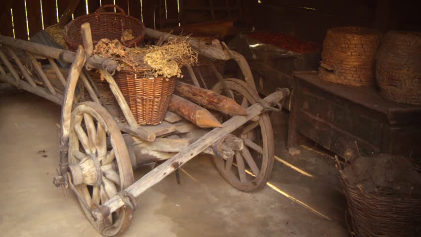 Wooden horse cart. loaded with fence posts and baskets. parked in an old barn on a rural farm in Ukraine. 4k Ultra HD video