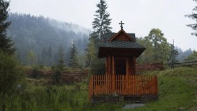Tiny. wooden chapel stands in a little meadow on the slopes of the picturesque. Carpathian Mountains in Ukraine. Video UltraHD 4k