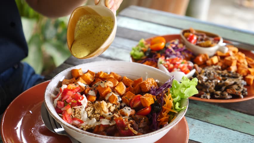Closeup Of Pouring Sauce On Vegan Bowl With Sweet Potato And Vegetables. Healthy Food. | Shutterstock HD Video #1021019188
