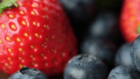 Close up footage of strawberries and blue berries fruits. Selective focus.