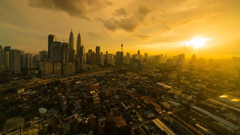 Dramatic and Beautiful Kuala Lumpur city skyline, aerial view overlooking busy city streets with busy light trails and national landmarks during dusk, during sunset. 4k ProRes