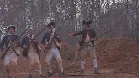 VIRGINIA - FALL 2018 - Reenactment, large-scale, epic American Revolutionary War anniversary recreation - in the midst of battle.  Continental Army Americans fire muskets on British Soldiers. Smoke