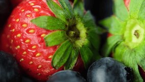 Close up footage of strawberries and blueberries fruit on wooden table top. Selective focus.
