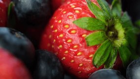 Close up footage of strawberries and blueberries fruit on wooden table top. Selective focus.