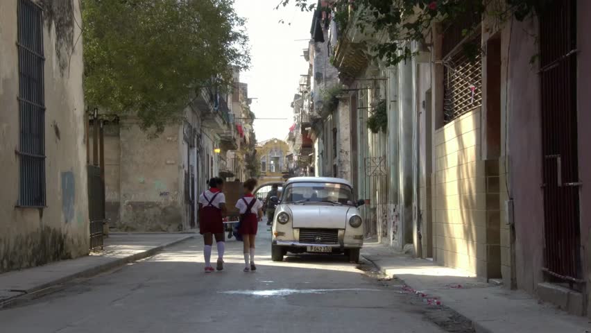 cuban school girls children walk in neighborhood alley street in old Havana, Cuba
