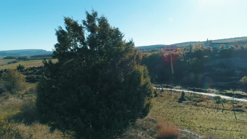 Road under rocky hill against the blue sky. Shot. Beautiful view from the top of hill.