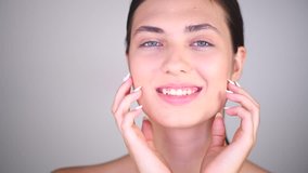 Beauty Girl Portrait. Beautiful Spa Teenager girl Touching her Face and smiling. Perfect pure Fresh Skin. Beauty brunette teen Model. Acne treatment, cleansing, Youth and Skin Care Concept. 4K UHD