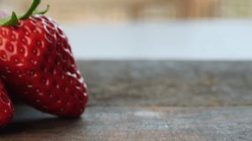 Close up footage of fresh strawberry fruits on wooden table top. Selective focus.