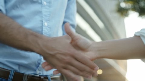 Close up slow motion footage of two business people shaking hands. Manager and his assistant shaking hands after important interview. Static shot. Successful people, business concept.