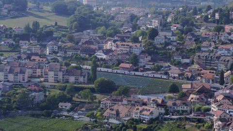 Chexbres, Vaud / Switzerland - 08 19 2018: August 2018 - Chexbres, Switzerland - Aerial shot of Swiss train passing through Chexbres village in Lavaux vineyard