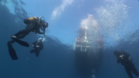 scuba divers underwater diving boat on the surface 