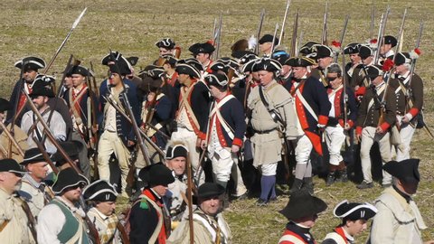 VIRGINIA - OCTOBER 2018 - Reenactment, large-scale, epic American Revolutionary War anniversary recreation -- U.S. Continental Army Soldiers in formation marching as on parade with Muskets, flags.