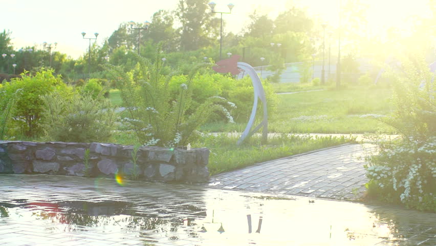 Happy cute little boy chid running playing having fun jumping through puddles in raincoat and rubber boots. laughing and smiling boy in park. rain slush spring summer autumn bad weather puddle cold