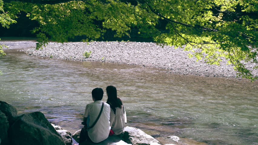  A couple sitting beside a river