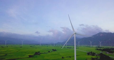 Wind turbine farm and agricultural fields on blue sky. Turbine green energy electricity or wind turbine in a green field - Energy Production with clean and Renewable Energy. Phan Rang, Vietnam