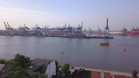 Revealing drone shot of Hamburg Övelgönne and container harbour background view in aerial drone shot. Elbe river in Germany 