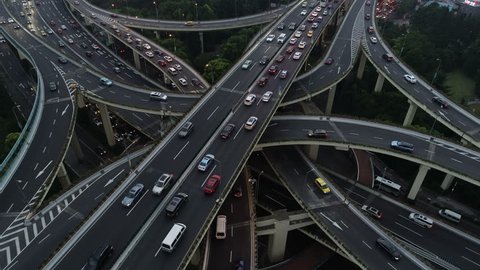 Rising tilting drone shot of spectacular intersection, rush hour commute in Shanghai city, transportation and infrastructure in urban China: stockvideo