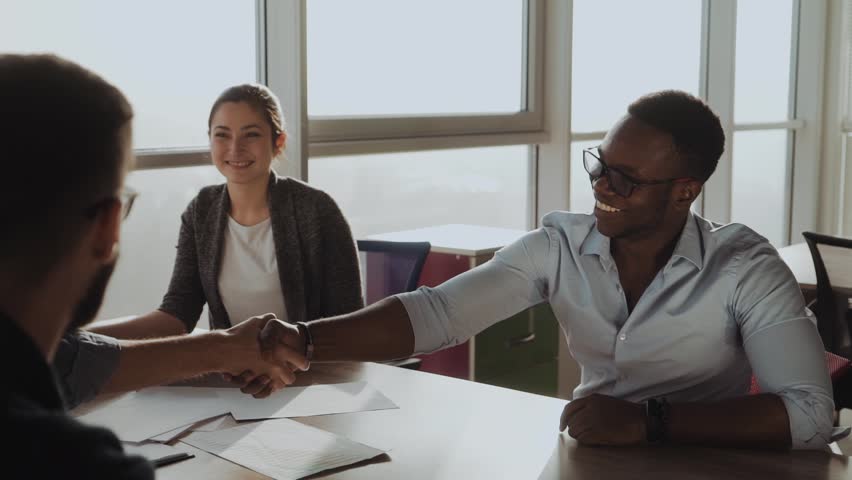 International handshake. Business, communication, startup and people concept - happy multiracial creative team at the office. | Shutterstock HD Video #1021105993
