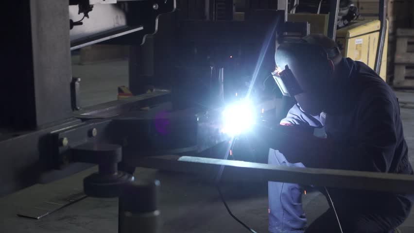 Industrial Worker labourer at the factory welding steel structure, repairing large appliances | Shutterstock HD Video #1021107610
