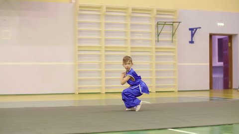Young boy in traditional blue yifu clothes for tai chi training nanquan exercise in sport club. Boy teenager practising Chinese martial art Wushu while workout. Chinese martial art tai chi concept
