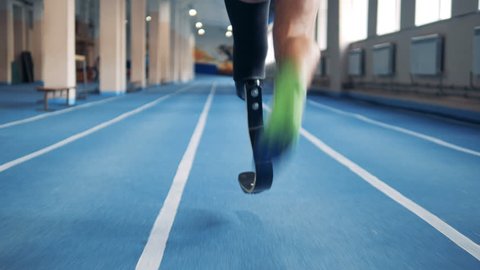 Close up of a male prosthetic leg and a healthy one during jogging