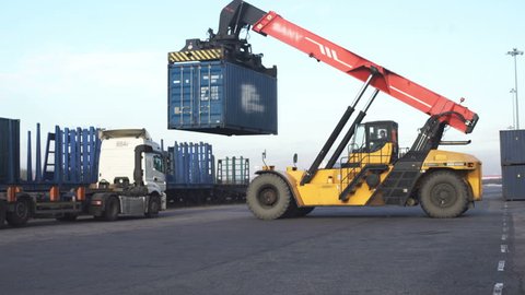 Forklift truck lifting cargo container in dock yard against sunrise sky for transportation import, Export and logistic industrial, Business logistic concept, Import and export concept.