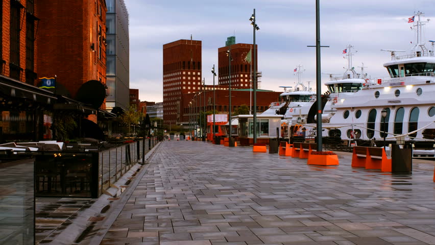 Oslo, Norway. Downtown Oslo, Norway, on a cloudy morning, with moored boats and minimalistic scandinavian-style buildings on the background. Empty promenade area