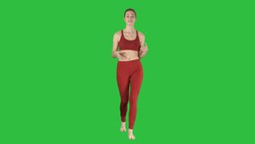 Beautiful young yoga instructor talking to camera on a Green Screen, Chroma Key.