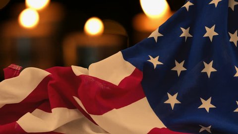 American flag lying with burning candles background