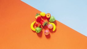 Tiny plastic fruits are spinning. The concept of healthy eating. Stop motion animation.