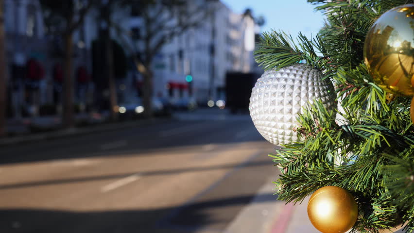 A slow motion view of traffic on Wilshire Boulevard decorated for Christmas.  	