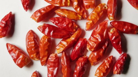 Some spicy hot peppers on a white background, in rotation.