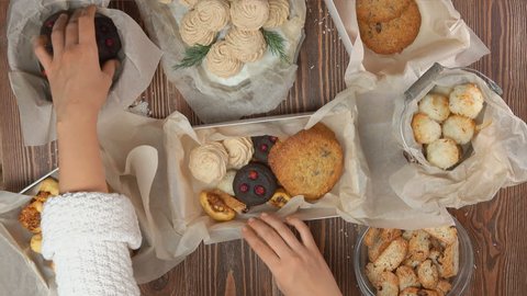 Confectioner puts into the New Year's gift box different types of fresh tasty cookies top view స్టాక్ వీడియో