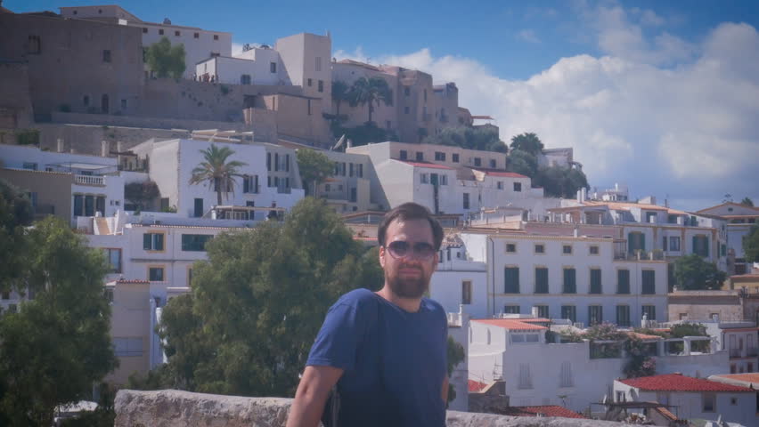 handsome young man in suglasses smiling in Dalt Vila in Ibiza Town. Old Town Eivissa